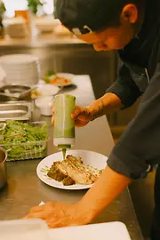 Un cuisinier agrémentant son plat au restaurant « Mimi im Stadtelefant »