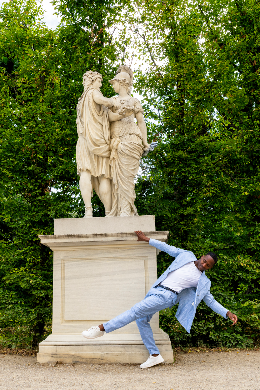 A man walking in front of a monument in the Schönbrunn Palace Park