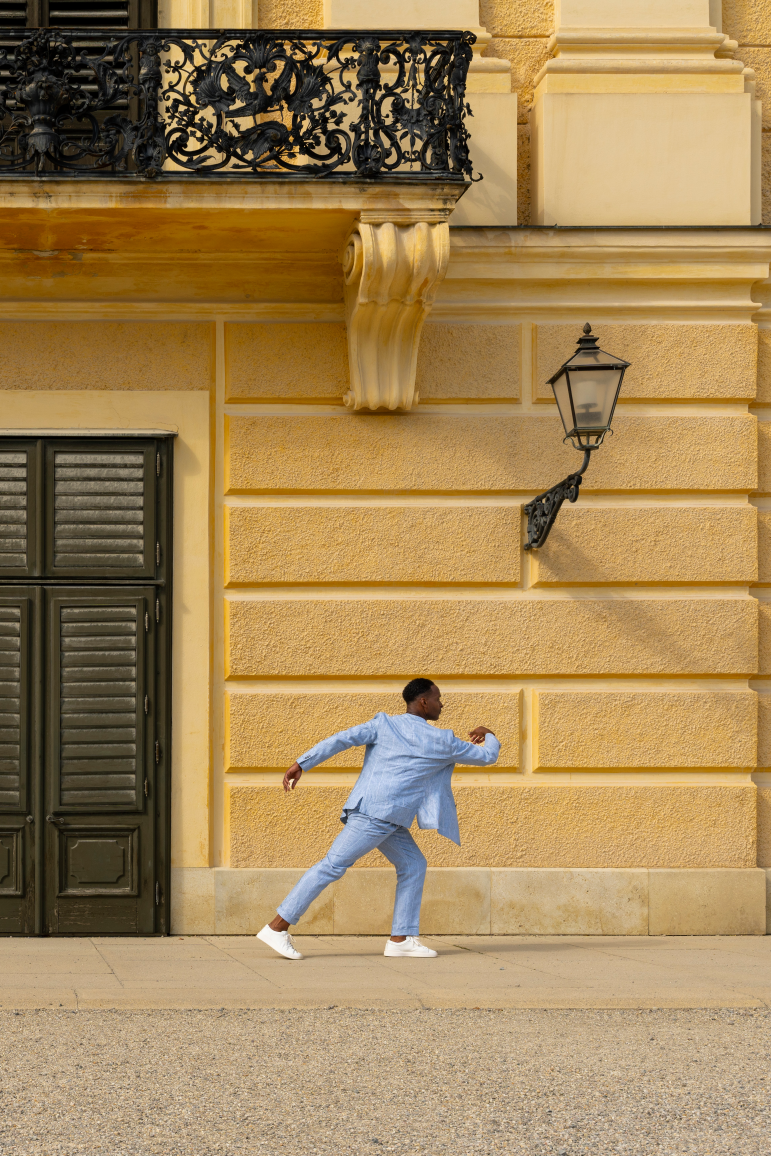 A man walking in front of the facade of Schönbrunn Palace