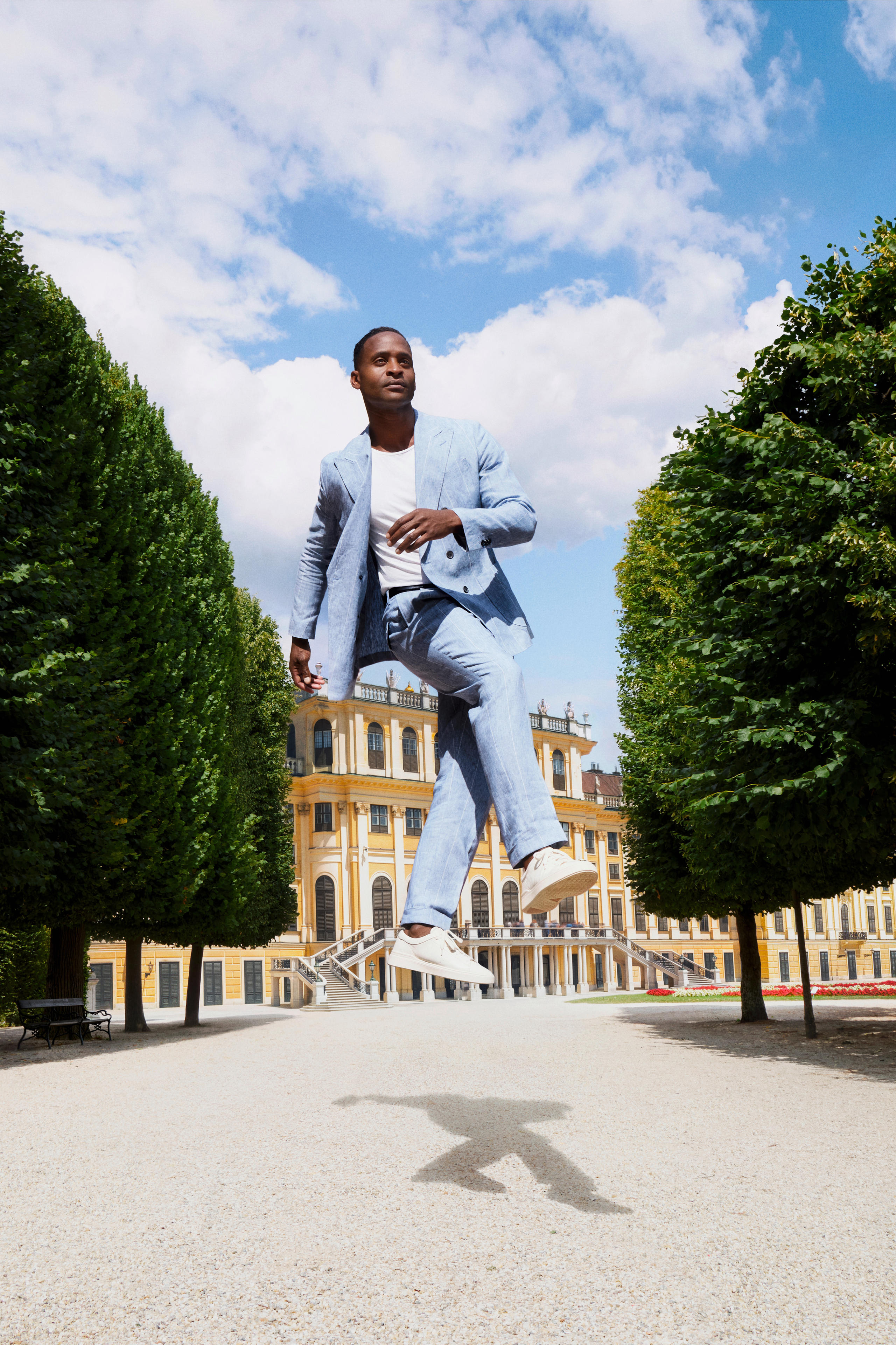 Imagen de campaña «Wanderful Vienna 2026»: hombre con traje flotando en los jardines del Palacio de Schönbrunn