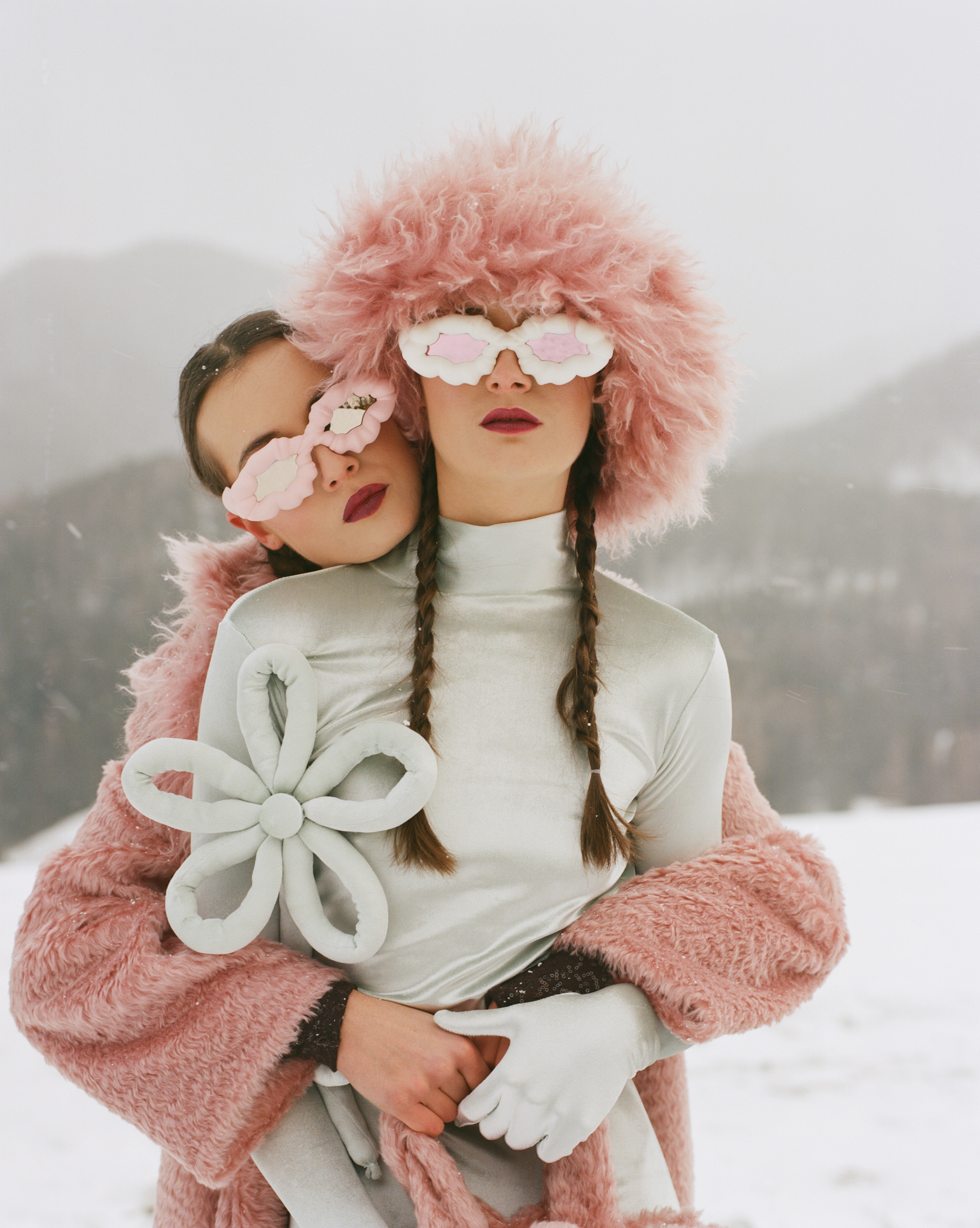 Two female models in front of a mountain landscape in the snow