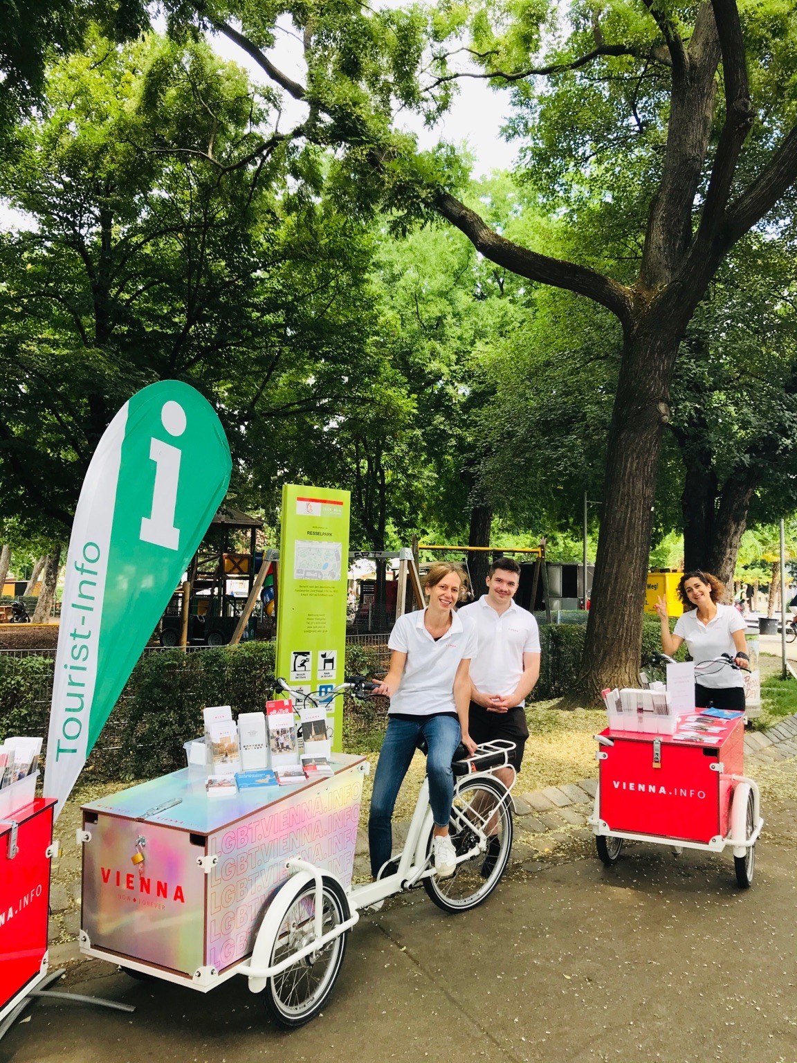 Dos bicicletas de carga con folletos de Viena y dos trabajadoras y un trabajador del servicio de información turística