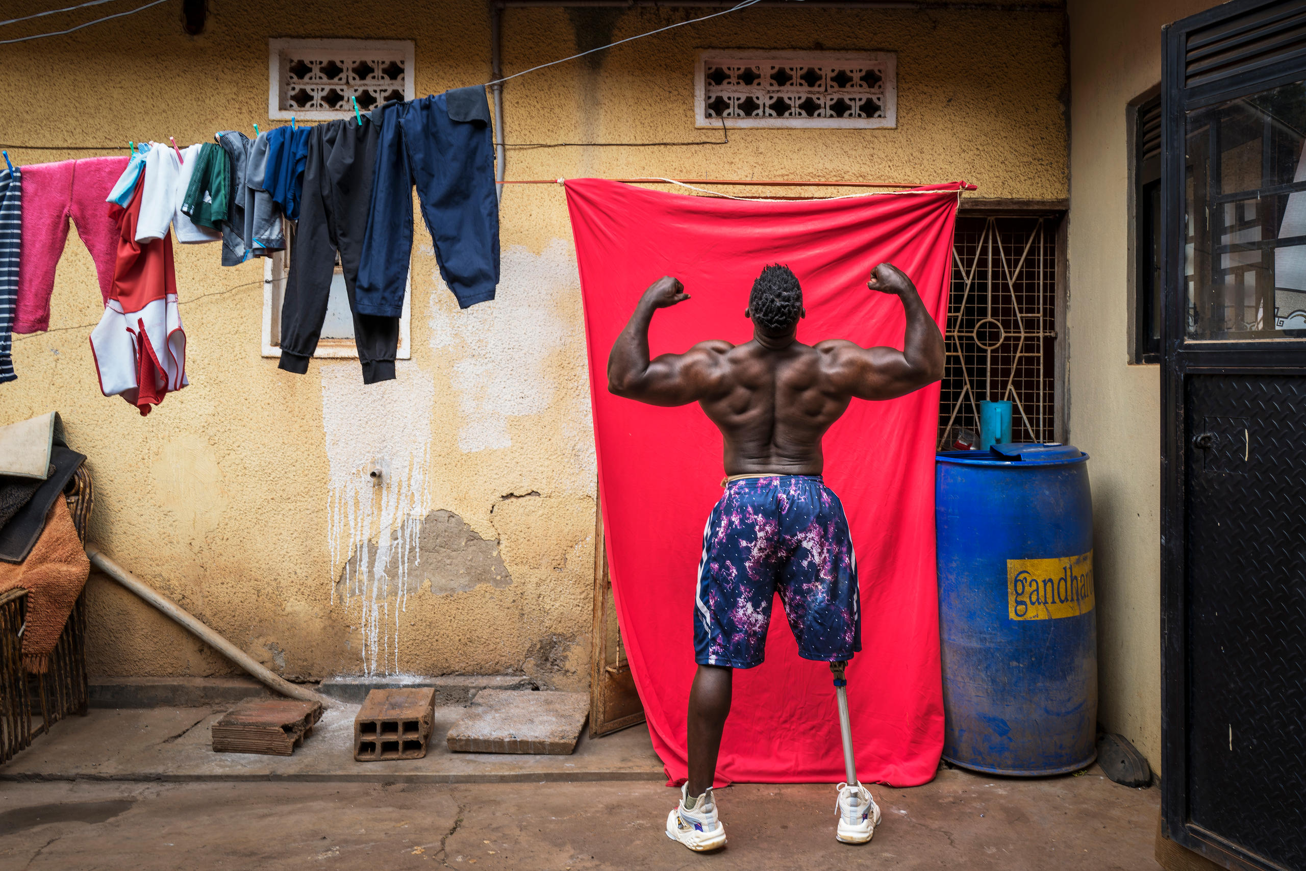Photograph, Bodybuilder Tamale Safalu trains in front of his home. Kampala, Uganda, 25 January 2024. 