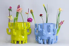 Two colorful ceramic vases by Onka Allmayer-Beck filled with spring flowers.