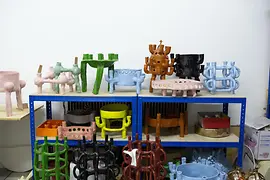 Colorful ceramic sculptures displayed on blue metal shelves.