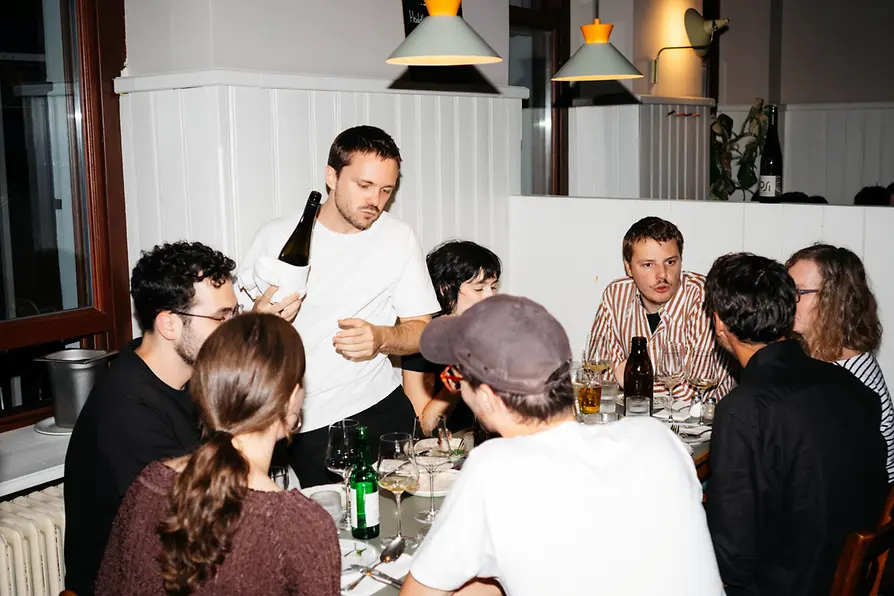 Freunde sitzen bei Essen und Trinken in einem Beisl