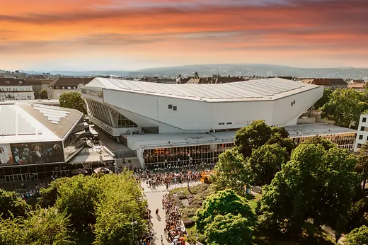 Luftaufnahme der Wiener Stadthalle in Abendstimmung, Menschen warten auf den Einlass