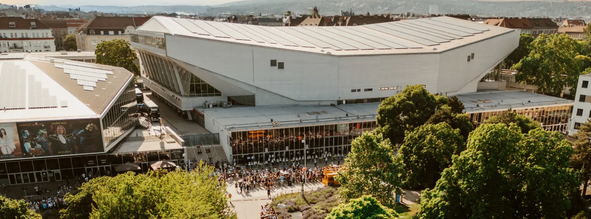 Aerial view of the Wiener Stadthalle at dusk, with people waiting to enter.
