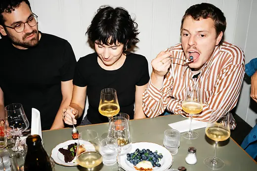 Freunde sitzen bei Essen und Trinken in einem Beisl
