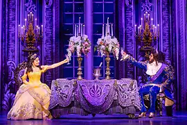 Belle and the Beast toast each other with champagne glasses.