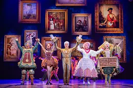 The musical characters Alarm Clock, Dancer, Candelabra, Eiffel Tower, and Wardrobe on stage.