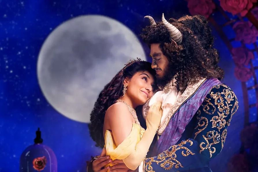 La Belle et la Bête enlacés, avec la pleine lune en arrière-plan.