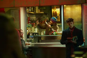 Menschen vor und in einem Würstelstand