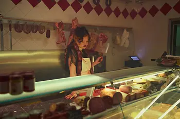 Mensch, der aussieht wie ein Vampir an Theke in Fleischerei