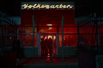 Menschen tanzen in rot ausgeleuchtetem Lokal mit Aufschrift "Volksgarten "