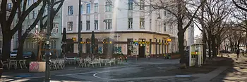 La Kriemhildplatz avec vue sur l’allée arborée de la Markgraf-Rüdiger-Straße et le Café Kriemhild.