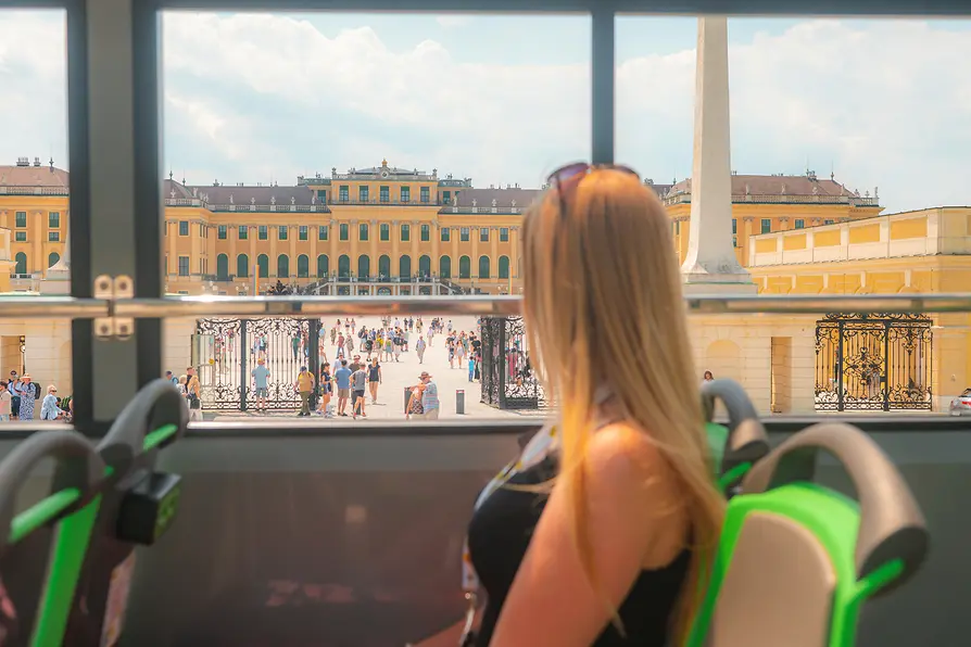 Junge Frau in einem Sightseeing Bus vor dem Schloss Schönbrunn