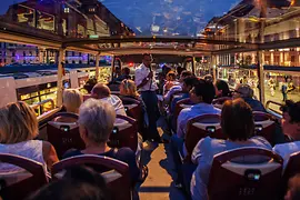 Passengers on a bus during a nighttime city sightseeing tour.