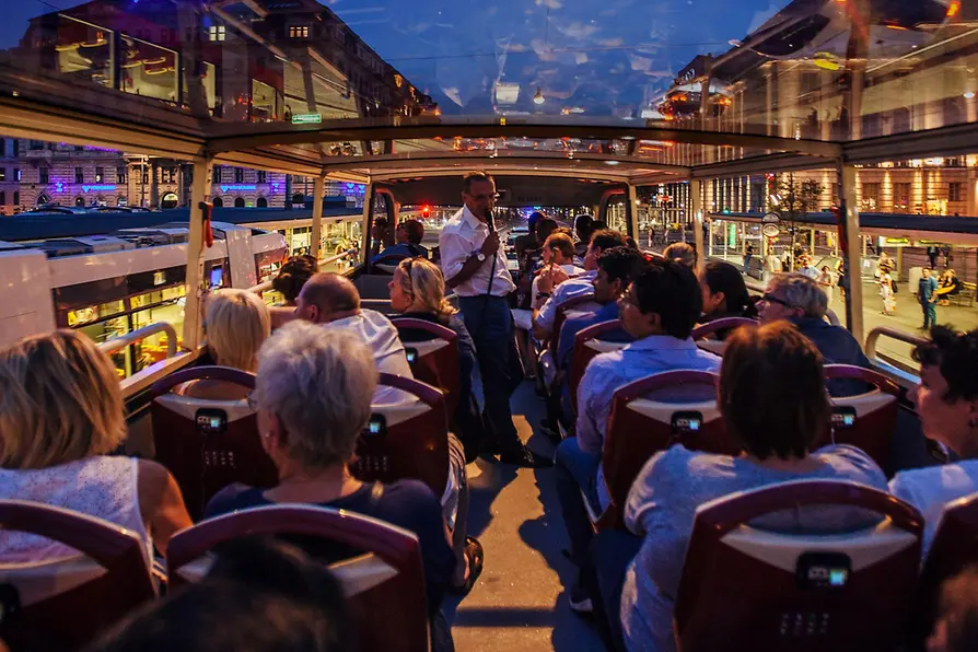 Personen im Bus bei einer Stadtrundfahrt bei Nacht 