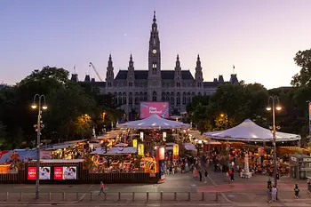 Blick auf die belebte Gastromeile beim Film Festival, dahinter das Wiener Rathaus.