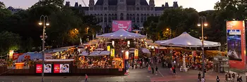View of the lively food and drink promenade at the Film Festival, with Vienna City Hall in the background.
