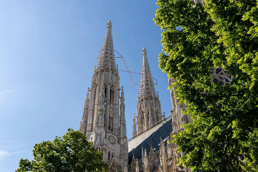 Außenansicht der Votivkirche mit Bäumen