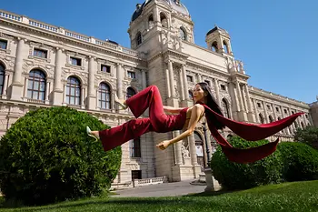 Woman is floating above gras in front of the Kunsthistorisches Museum Vienna