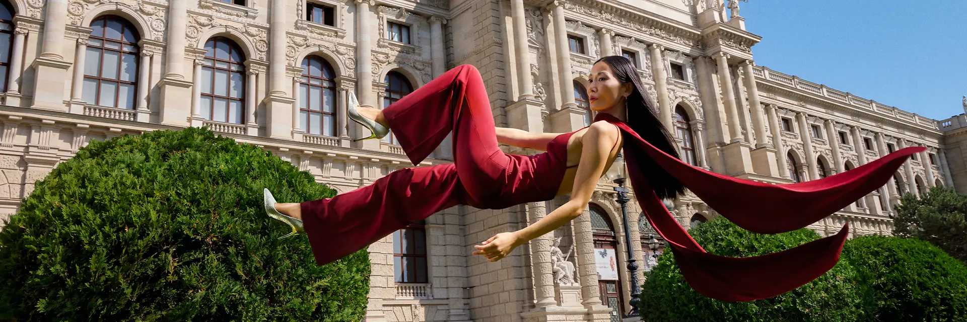 Woman is floating above gras in front of the Kunsthistorisches Museum Vienna