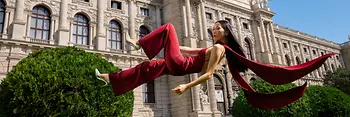 Woman is floating above gras in front of the Kunsthistorisches Museum Vienna