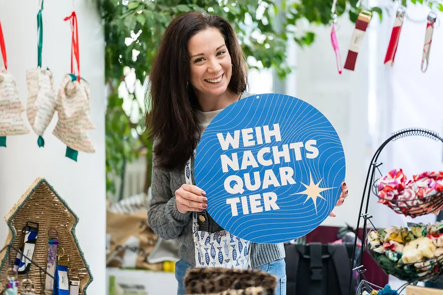 A woman at a booth at a designer Christmas market