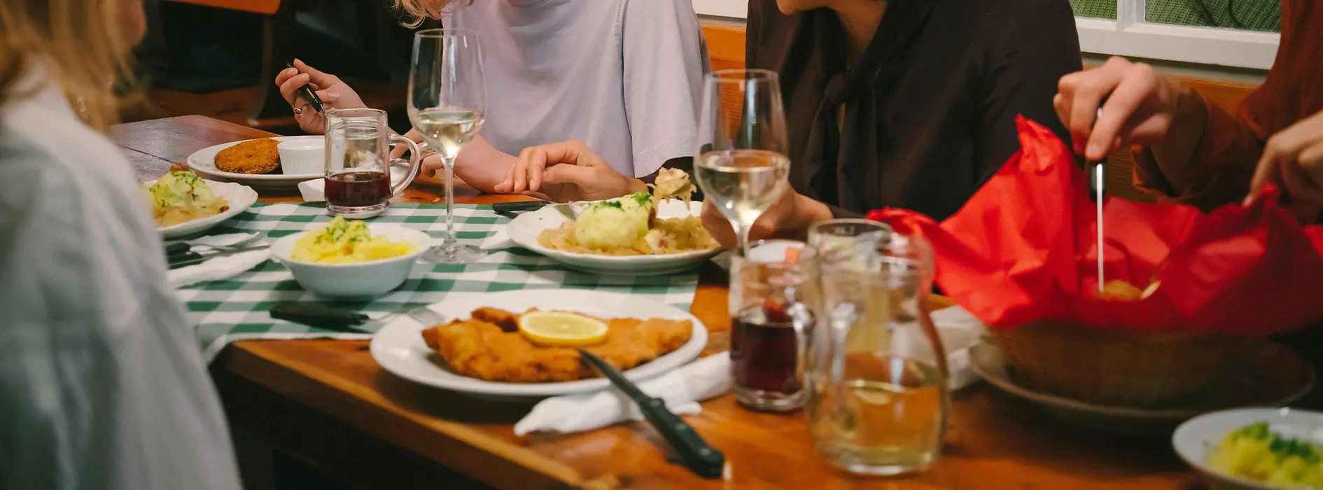 Гости едят венский шницель в винном трактире-хойригер