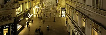 Gente a passeggio di notte nella piazza Kohlmarkt suggestivamente illuminata