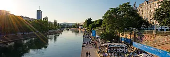Люди в шезлонгах в лучах солнца на Дунайском канале