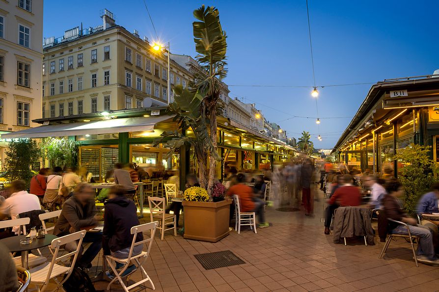 Színes forgatag a Naschmarkt szórakozóhelyein, külső nézet emberekkel 