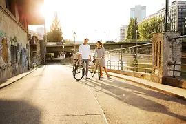 Two cyclists by the Danube Canal