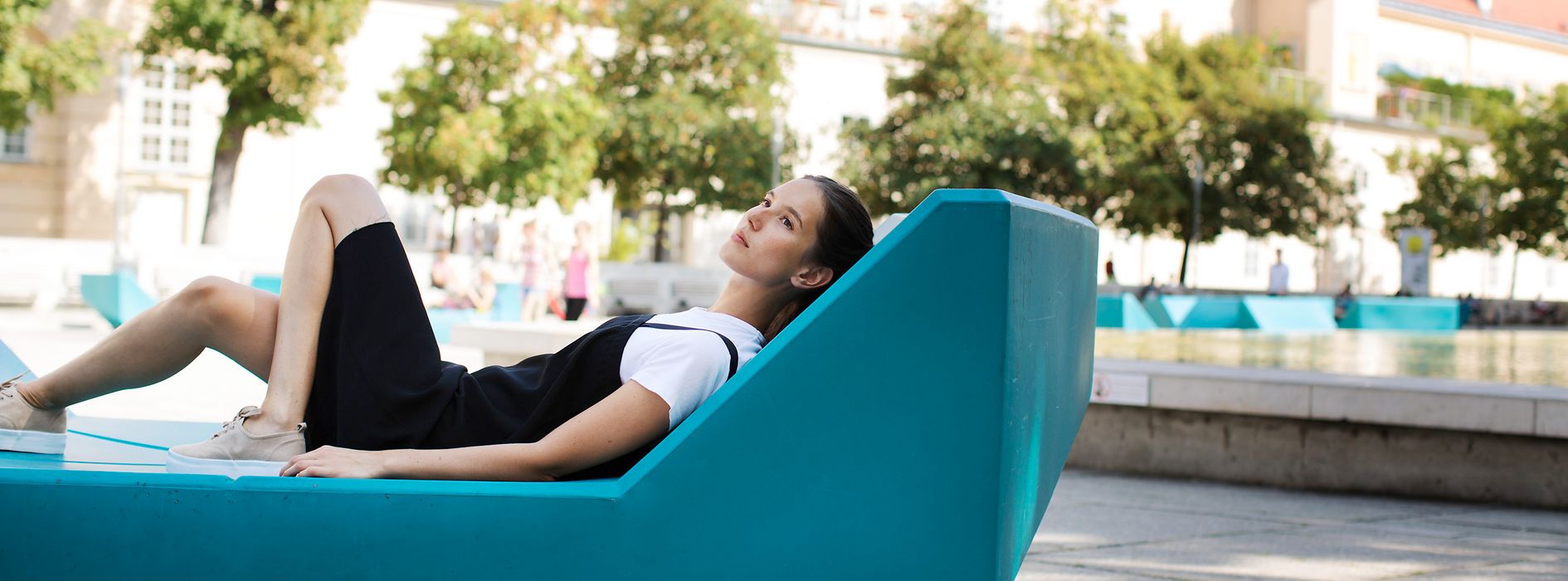 Woman lying on outdoor furniture in the inner courtyard of the MuseumsQuartier