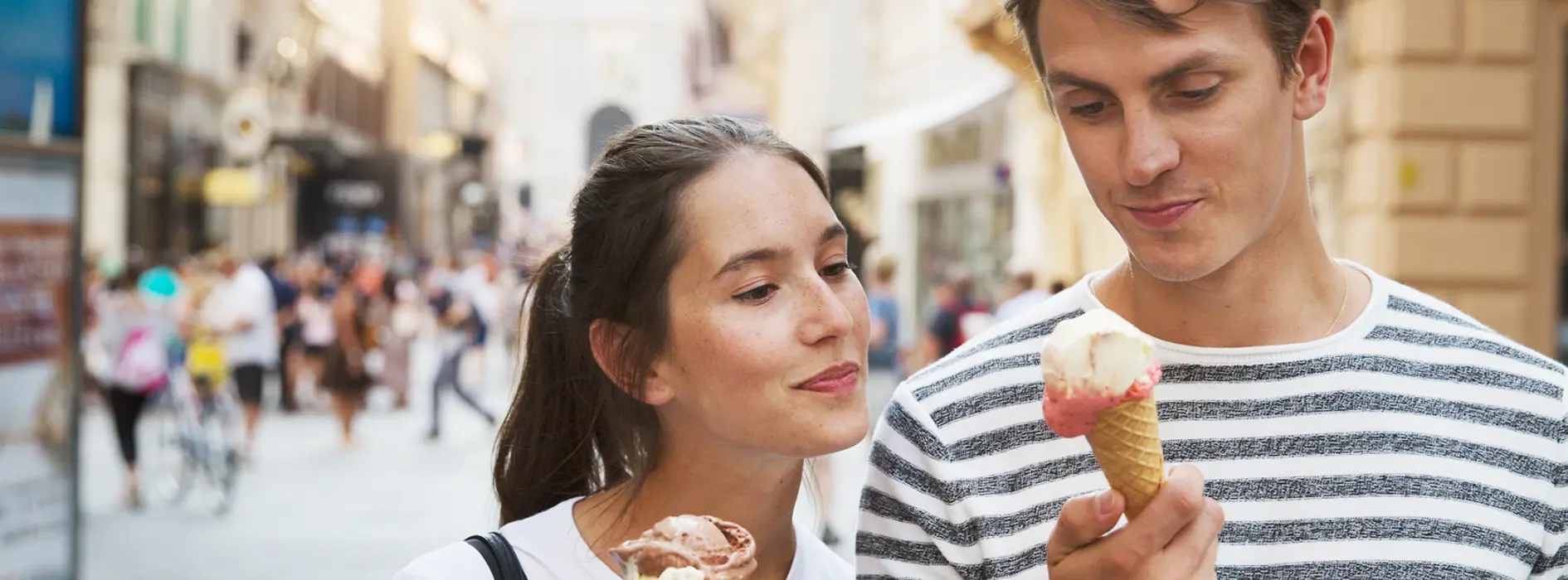 Pareja tomando helado mientras pasea por el casco antiguo
