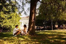 A couple sitting under the trees in Vienna's Burggarten