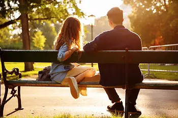 Pereche de tineri pe o bancă din Parcul Burggarten