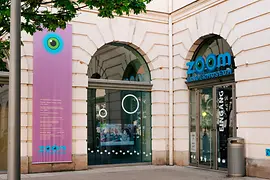 Façade of the ZOOM Children's Museum bedecked in colorful flags