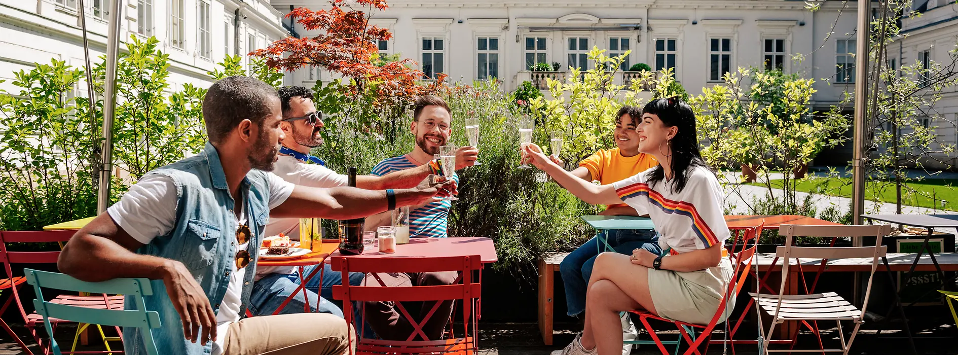 Grup de tineri beau împreună pe o terasă stradală