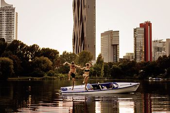 A man and a woman jump from a boat into the water
