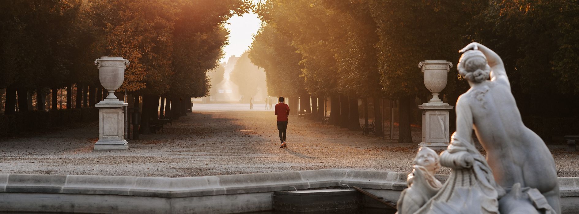 シェーンブルン宮殿庭園の並木道を走る人たち