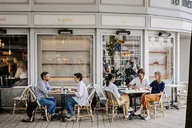 Menschen sitzen vor einem Café im Freien