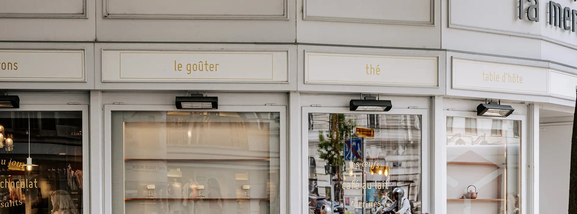 Menschen sitzen vor einem Café im Freien