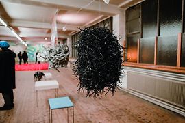 Im Raum hängende Skulpturen in einer Galerie