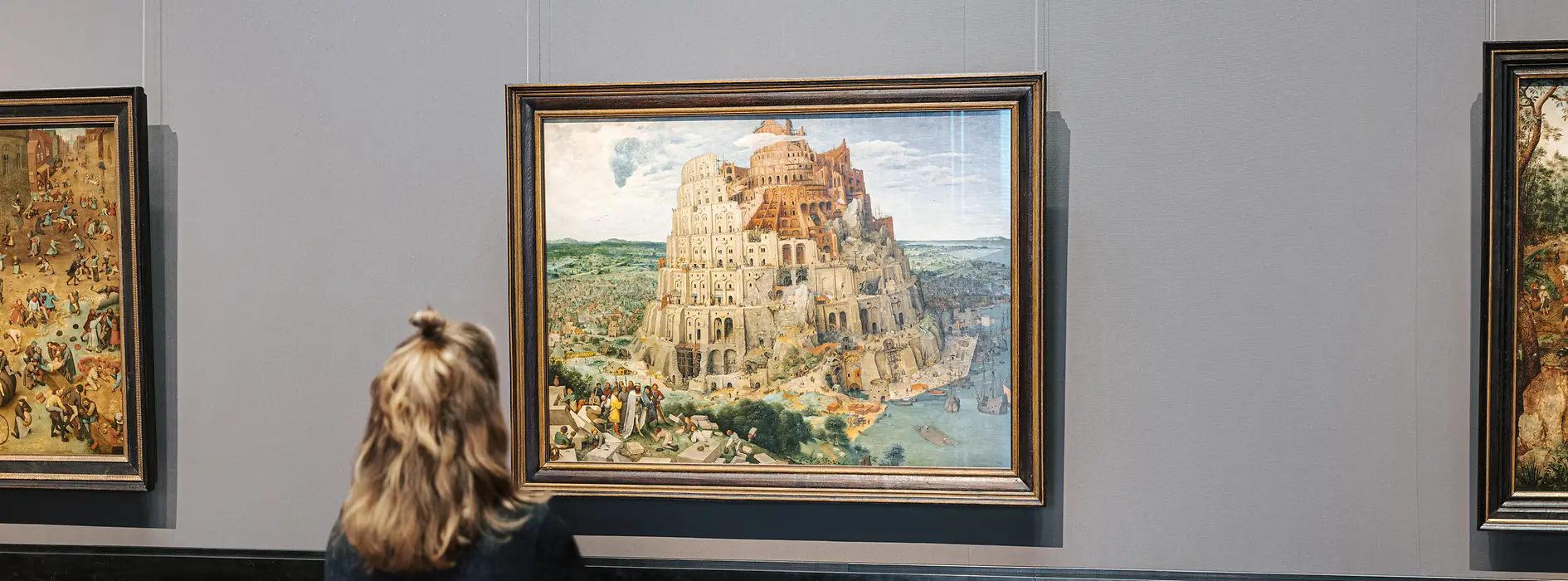 Visitor standing in front of the painting "Tower of Babel" by Pieter Bruegel at the Museum of Fine Arts in Vienna