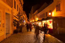 Mercatino di Natale in Spittelberg, atmosfera serale con luminarie natalizie e visitatori 
