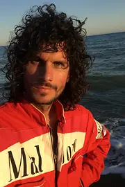 DJ and producer Wolfram in a vintage Formula 1 suit by the sea