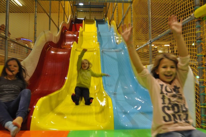 Family Fun, three girls on a big coloured slide